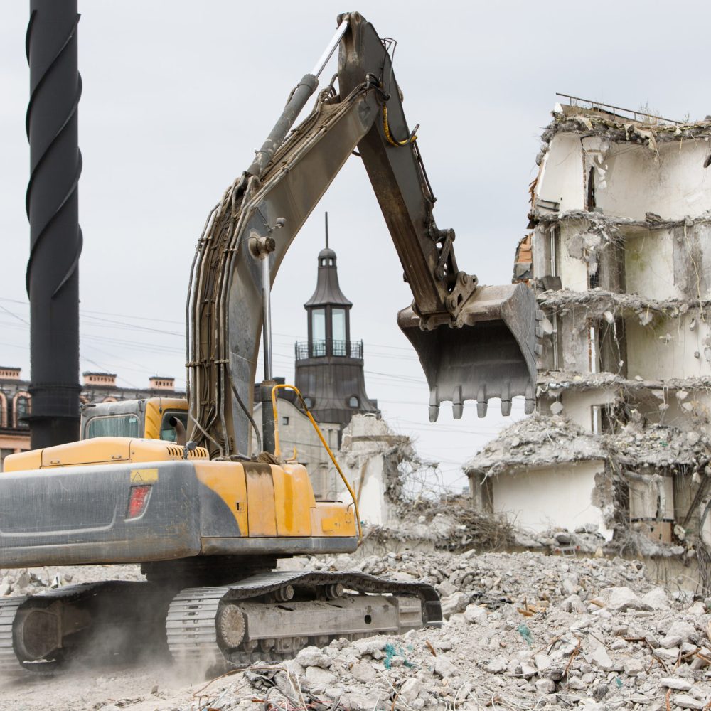 Building of the former hotel demolition for new construction, using a special hydraulic excavator-destroyer. Dismantling of house.