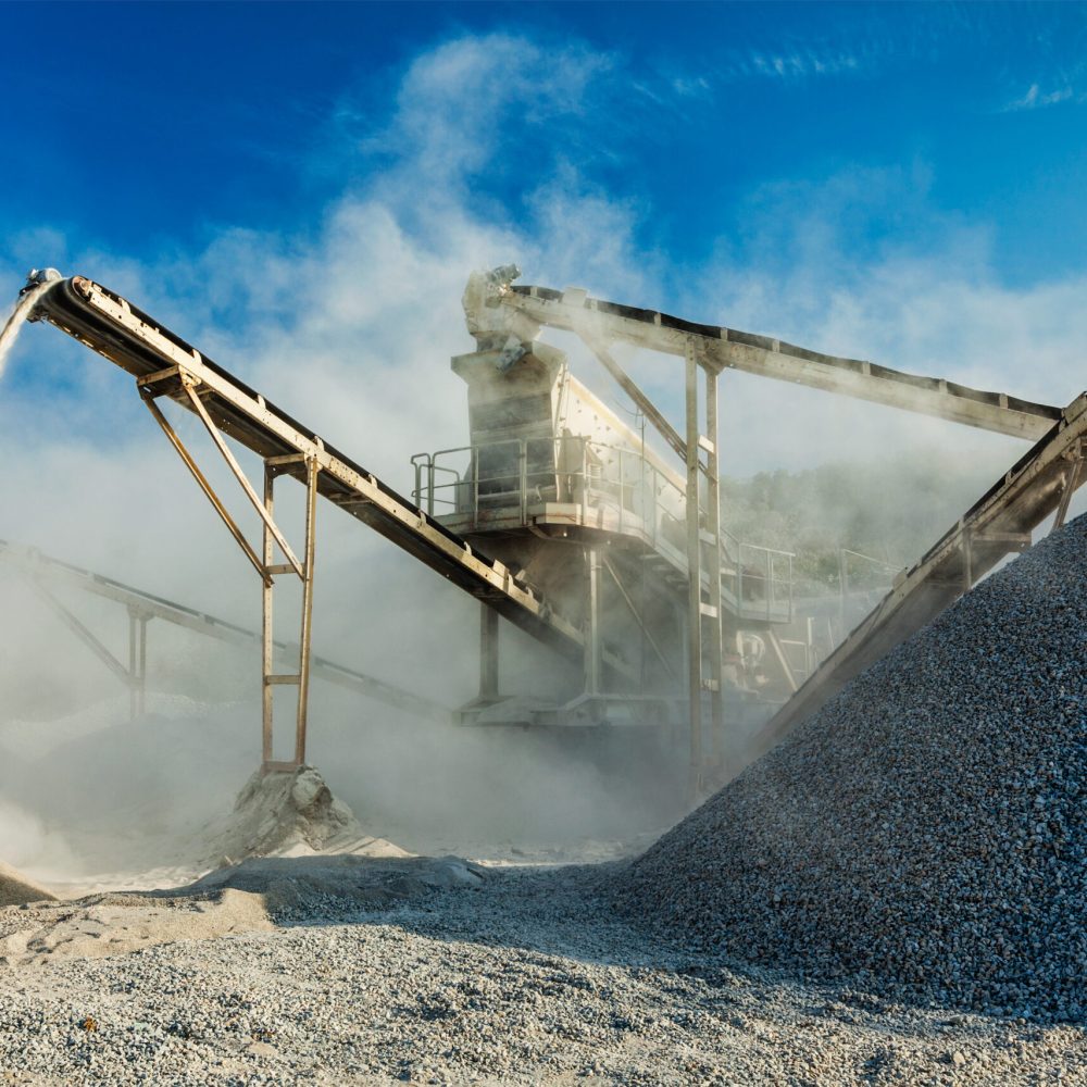 Industrial background - crusher rock stone crushing machine at open pit mining and processing plant for crushed stone, sand and gravel