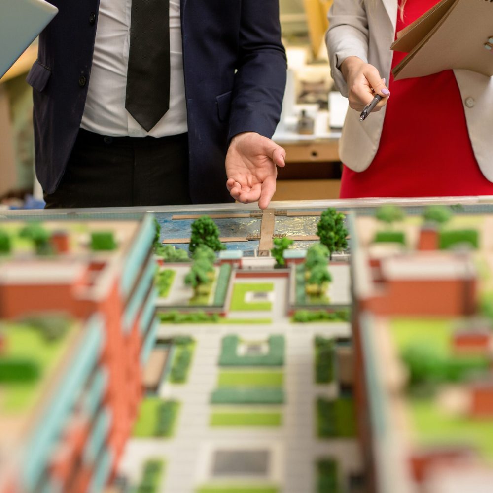 One of architect pointing at part of city layout during presentation of his project